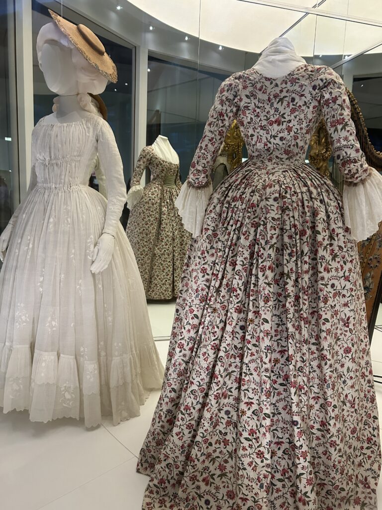 two 18th century dresses in Marie Antoinette's style - one white muslim, one floral